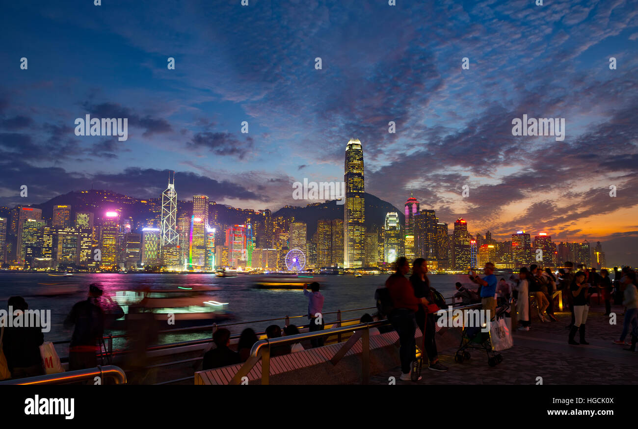 Il famoso quartiere Tsim Sha Tsui promenade e turisti che si godono la sera il panorama dell'Isola di Hong Kong, Hong Kong, Cina. Foto Stock
