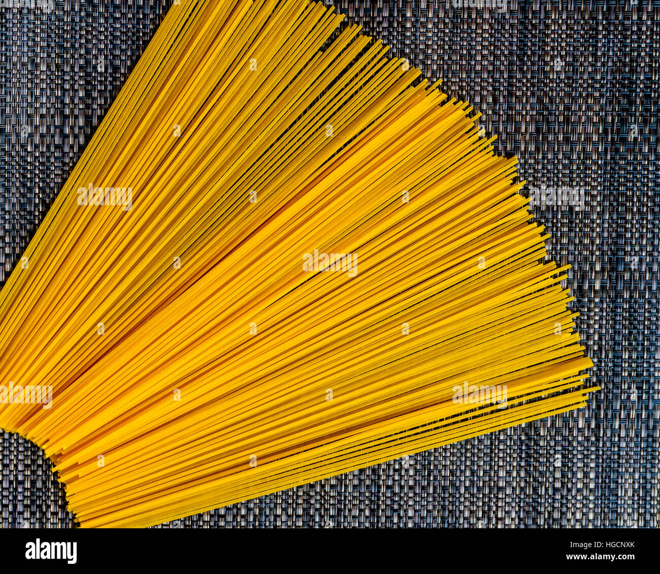 Non cotti gli spaghetti ventaglio su un tessuto grigio placemat Foto Stock