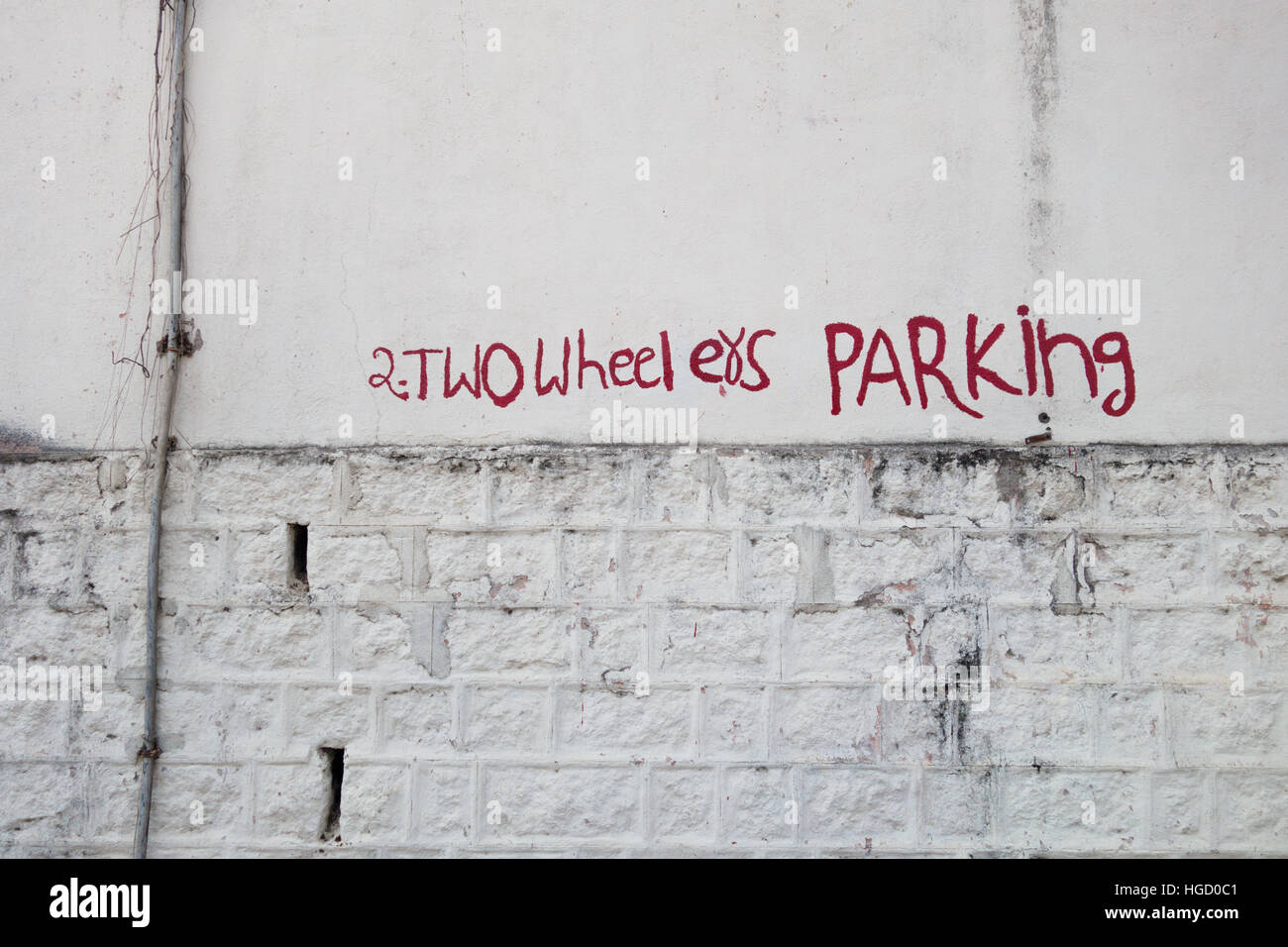 Funny due ruote parcheggio testo dipinta su un muro bianco Foto Stock