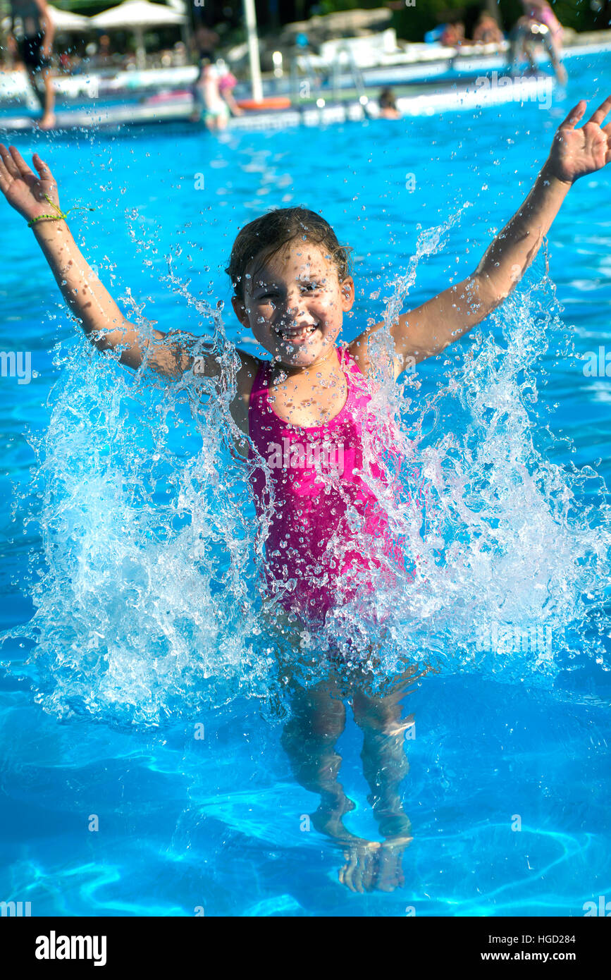Giovane ragazza in vacanza spruzzi in piscina, Maiorca, Baleari, Spagna Foto Stock