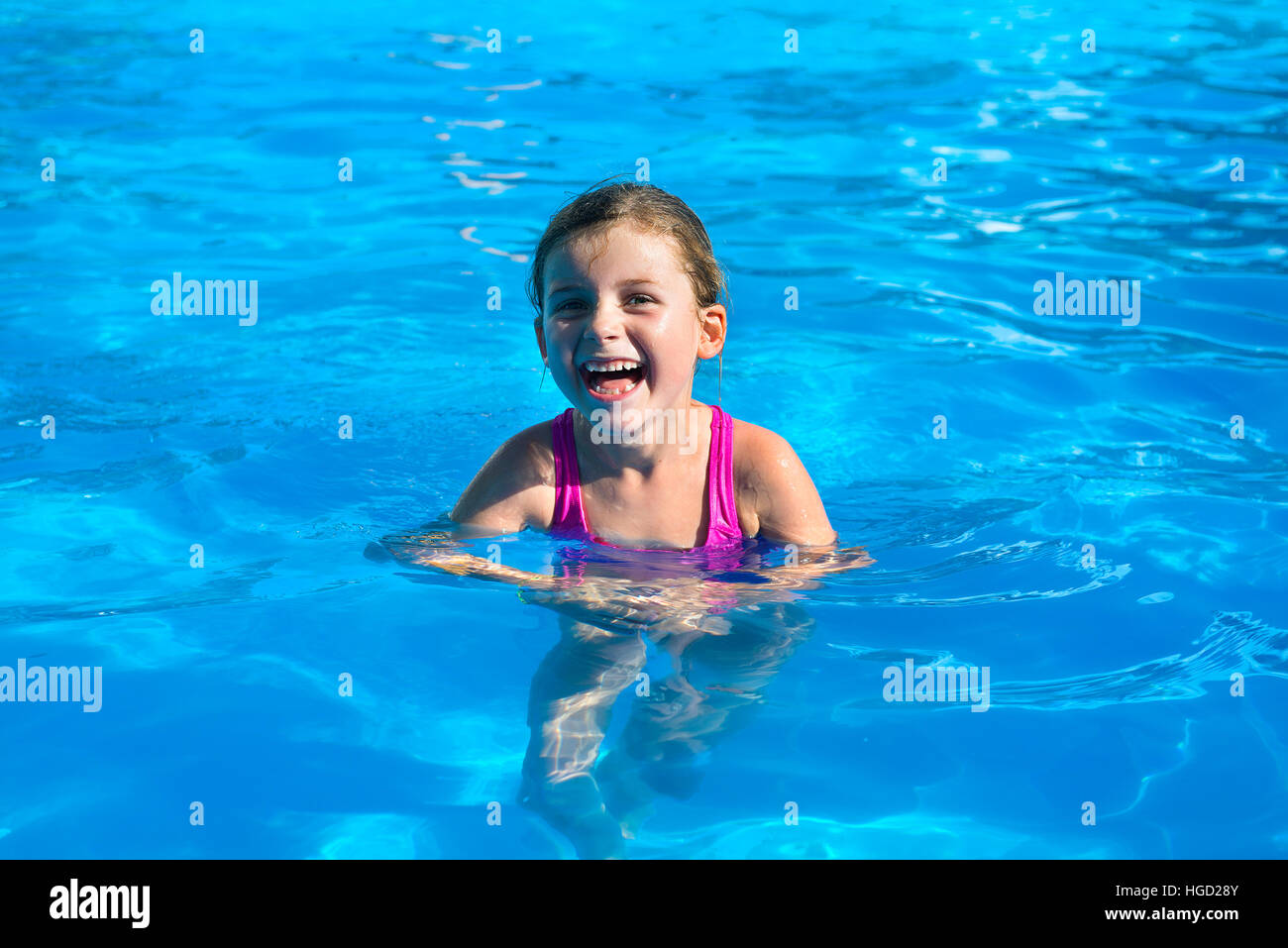 Ragazza giovane in vacanza a ridere in piscina Foto Stock