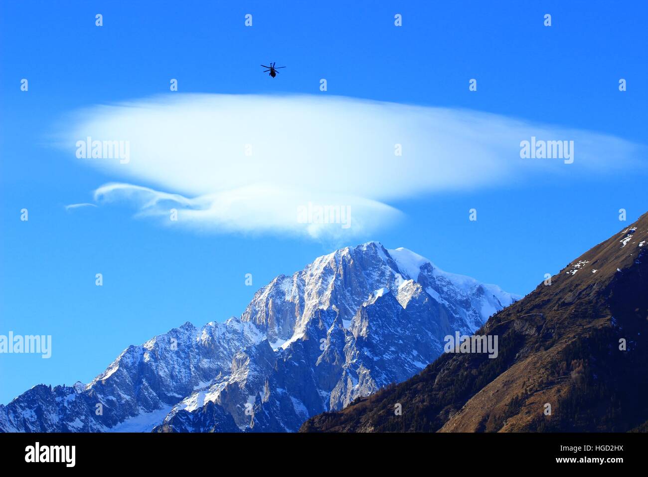 Salvataggio in elicottero in volo, Mont Blanc peak con cloud lenticularis sopra in background Foto Stock