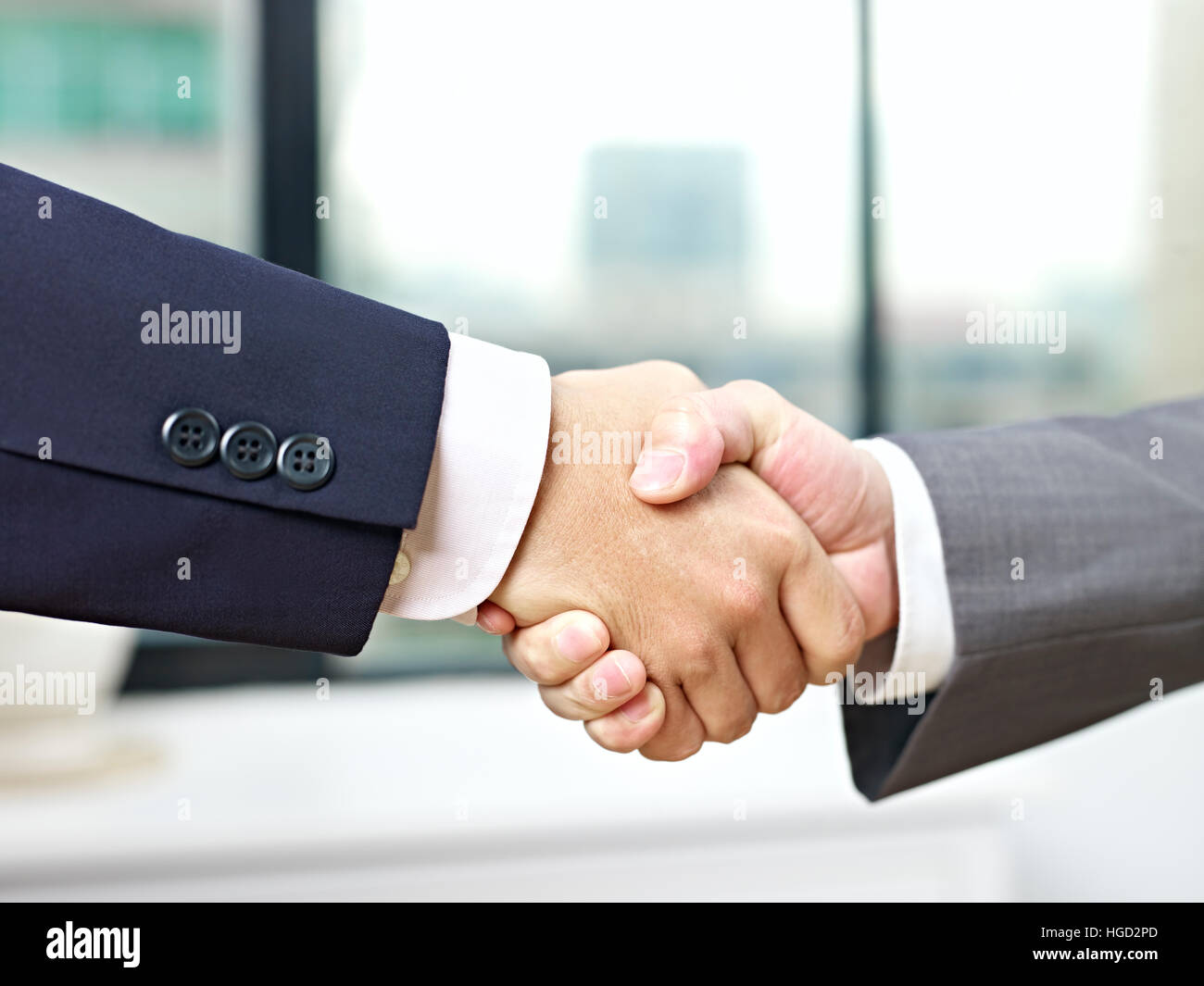 Close-up di una stretta di mano ferma in ufficio da parte di due imprenditori asiatici. Foto Stock