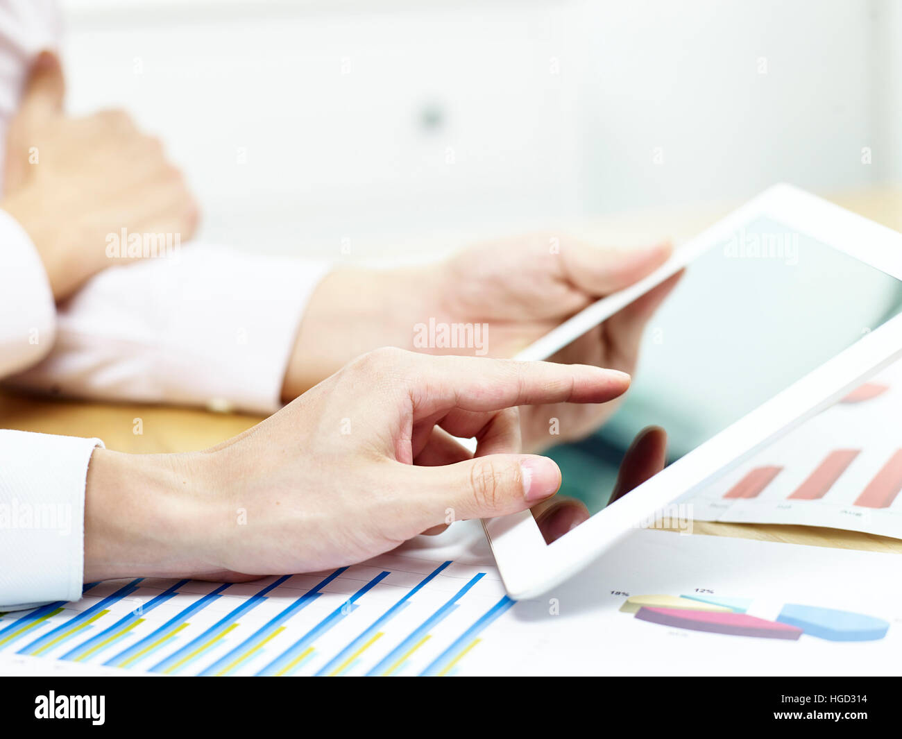 Due imprenditori discutere di affari in ufficio utilizzando un tablet. Foto Stock