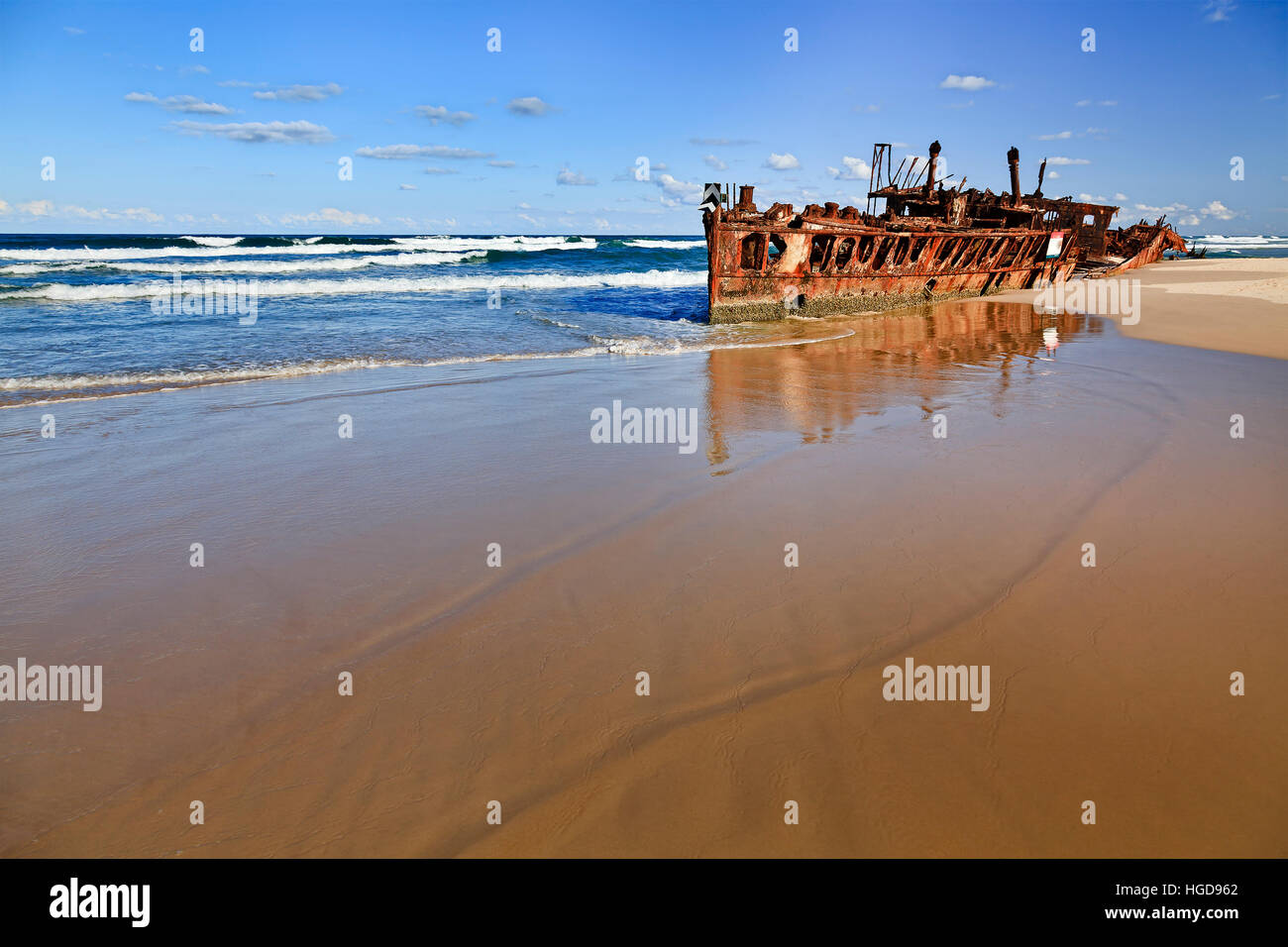 Maheno SS naufragio sulla spiaggia di sabbia di Fraser Island contro aperto oceano pacifico orizzonte. Spiaggia vuota si imbeve superficiale liscia riflettente onde rusty Foto Stock