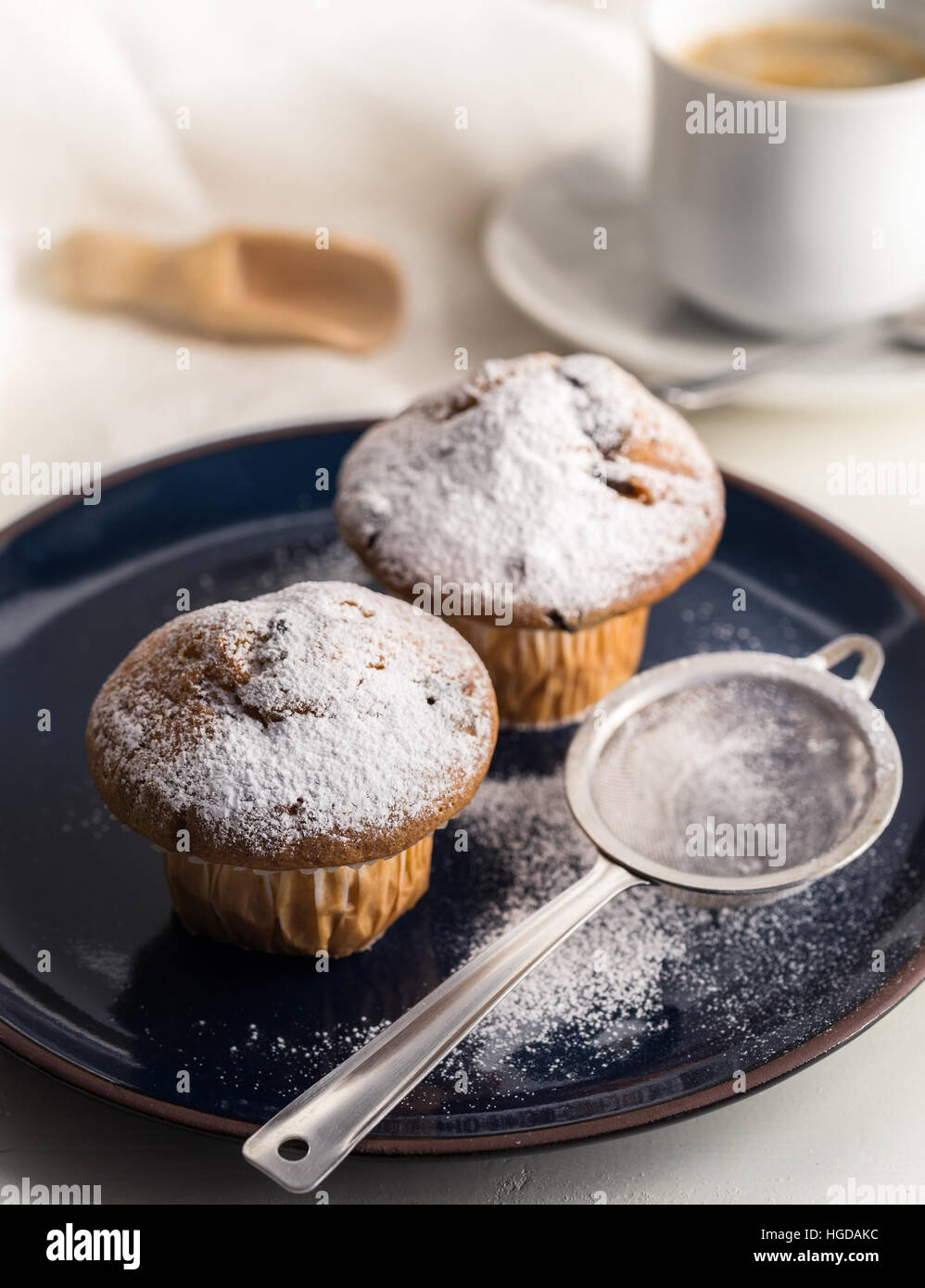 La prima colazione con i muffin con zucchero a velo sul blu scuro piastra. Foto Stock