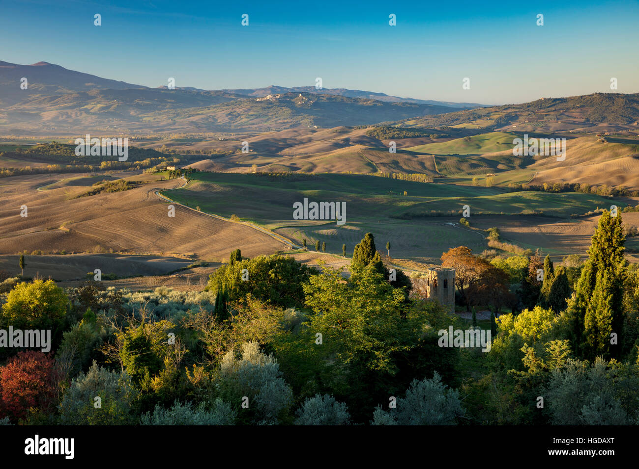 La mattina presto vista sulla Pieve di Corsignano e la campagna toscana al di sotto di Pienza, Toscana, Italia Foto Stock