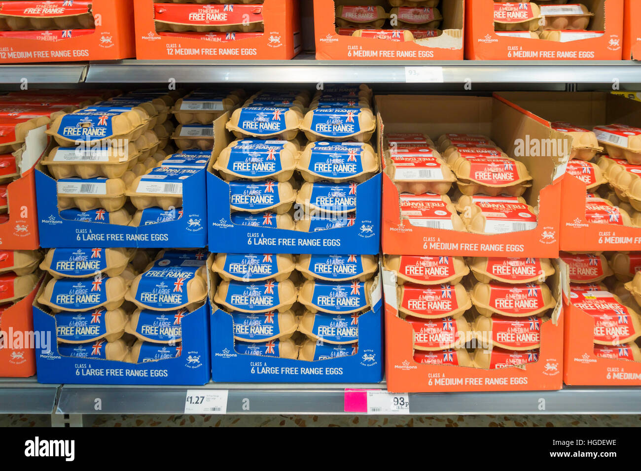 Supermercato display del free range uova le caselle rosse di medie dimensioni e caselle blu per grandi. Foto Stock