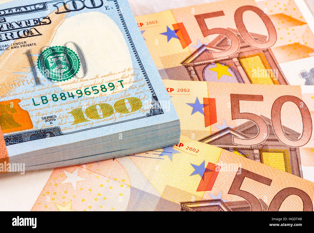 Pila di un centinaio di american le fatture del dollaro e le banconote in euro da vicino Foto Stock