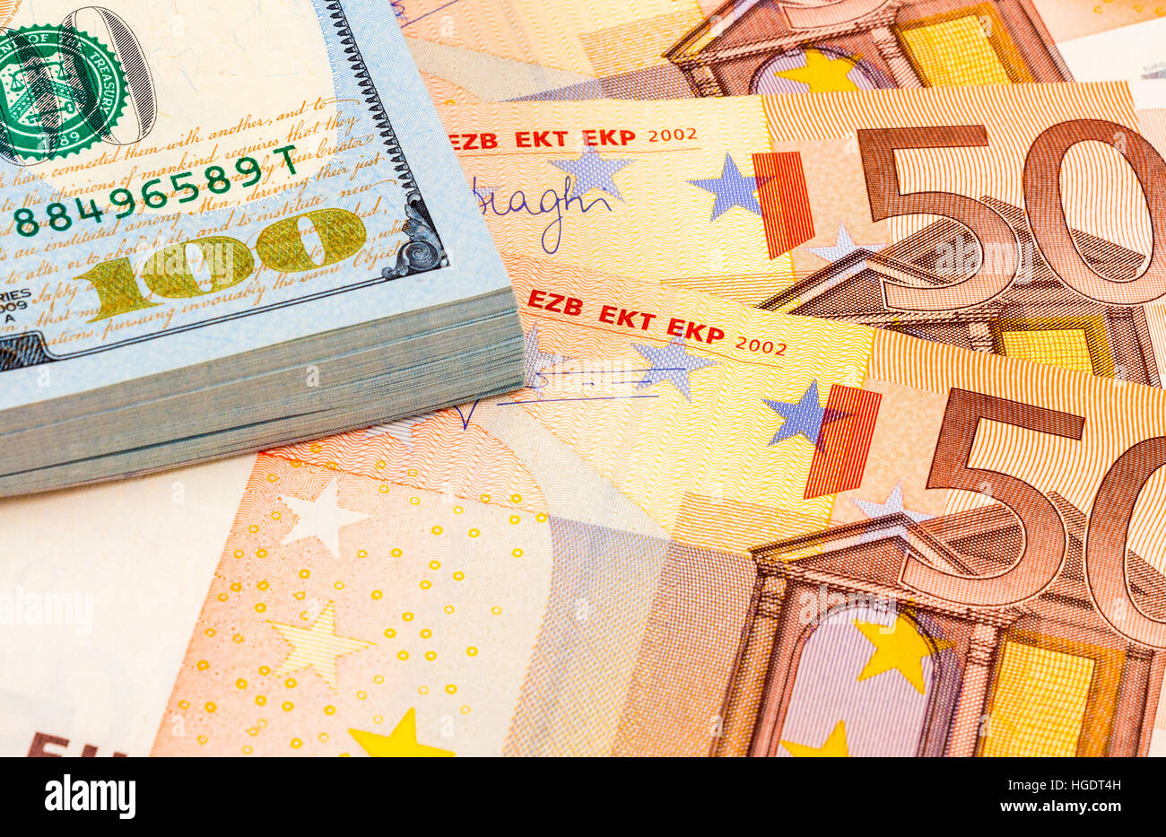 Pila di un centinaio di american le fatture del dollaro e le banconote in euro da vicino Foto Stock