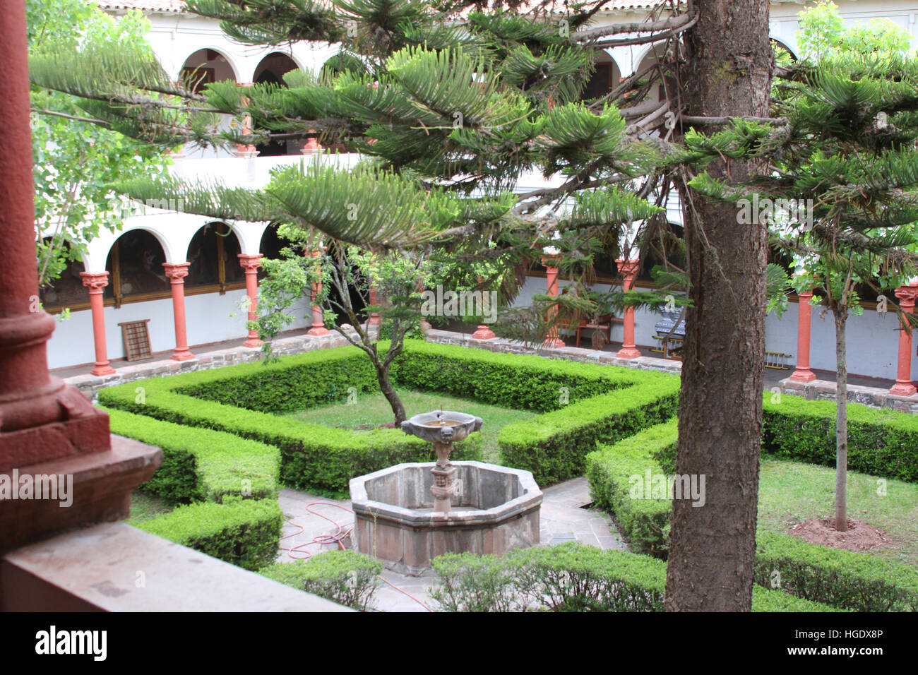 Cusco, Perù - Dicembre 14, 2016: dettaglio del giardino del cortile nella chiesa di San Francisco con siepi, fontana e pino in Cusco, Perù il 14 dicembre Foto Stock