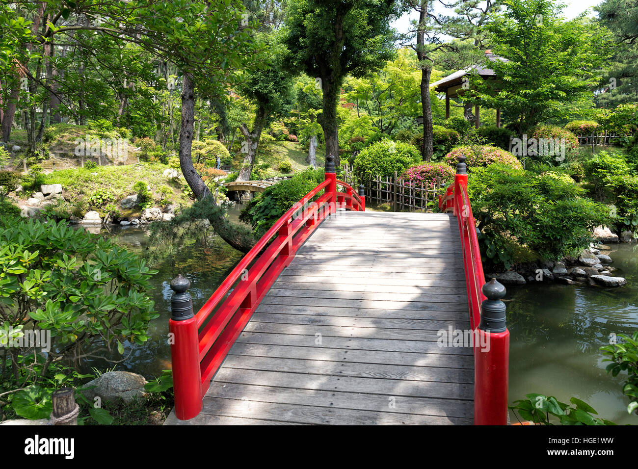 Rosso classico ponte in un giardino giapponese, Shukkeien, Hiroshima Foto Stock