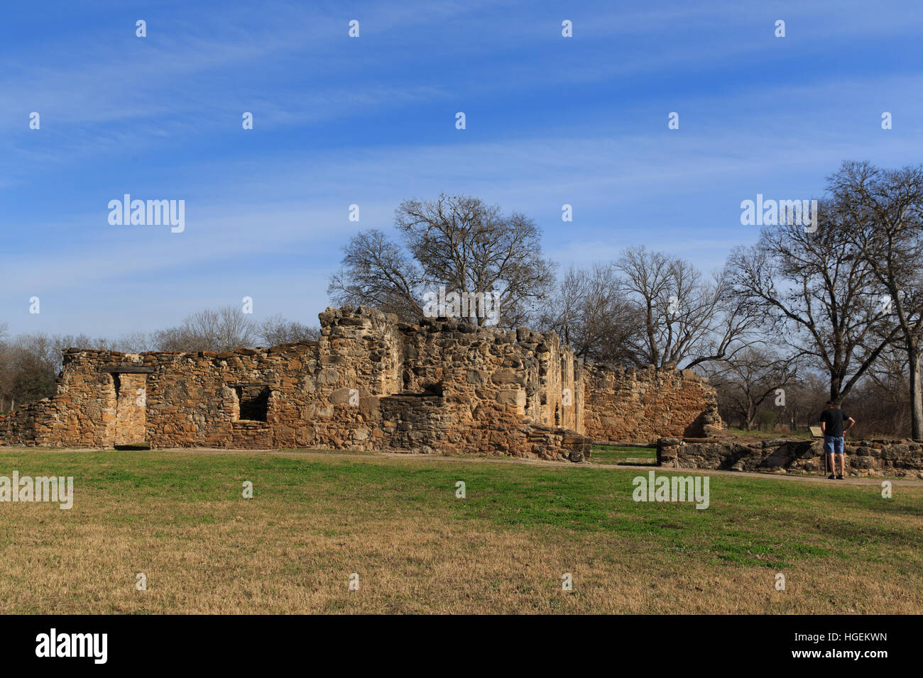 L'uomo legge sulle rovine presso la missione di San Juan a San Antonio, TX, Stati Uniti d'America. Foto Stock