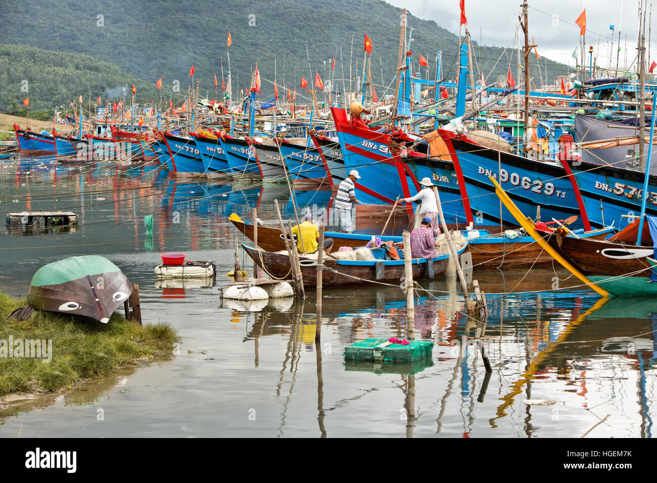 Ancorate barche da pesca della predizione del tifone che sopraggiungono, pescatori riassettavano le reti. Foto Stock
