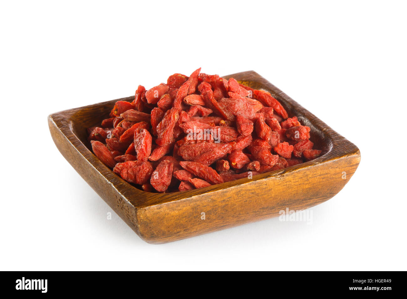 Bacche di Goji nella ciotola di legno isolato su sfondo bianco. Super Foto Stock