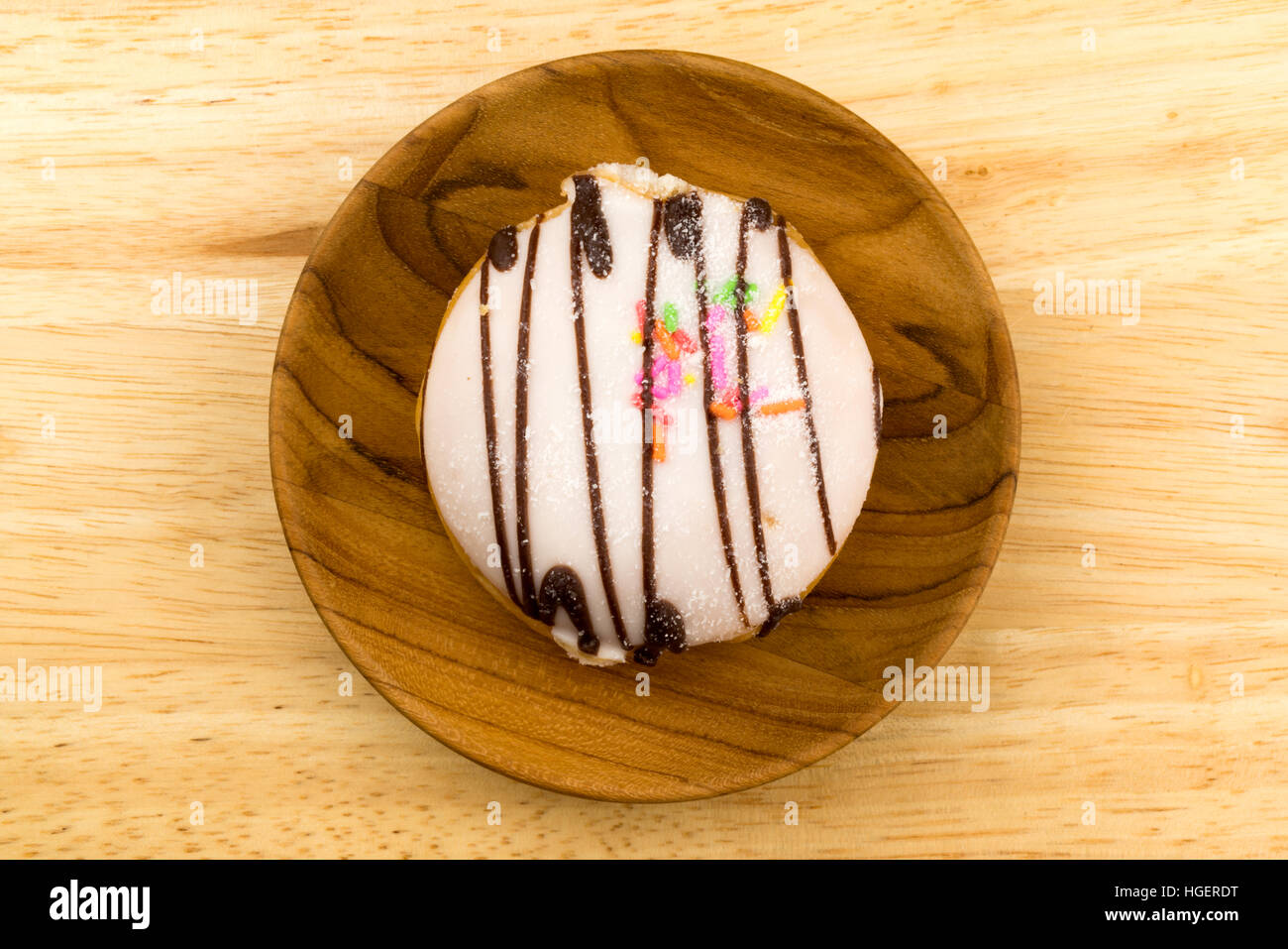 Deliziosa ciambella in un piatto di legno sul pannello di legno Foto Stock