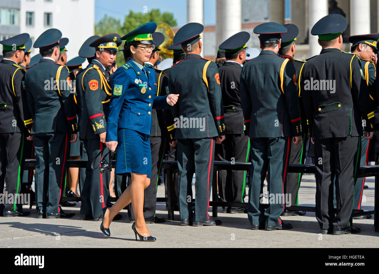 La donna in uniforme militare di estensione passato un gruppo di membri maschili di mongolo armee, Ulaanbaatar, in Mongolia Foto Stock