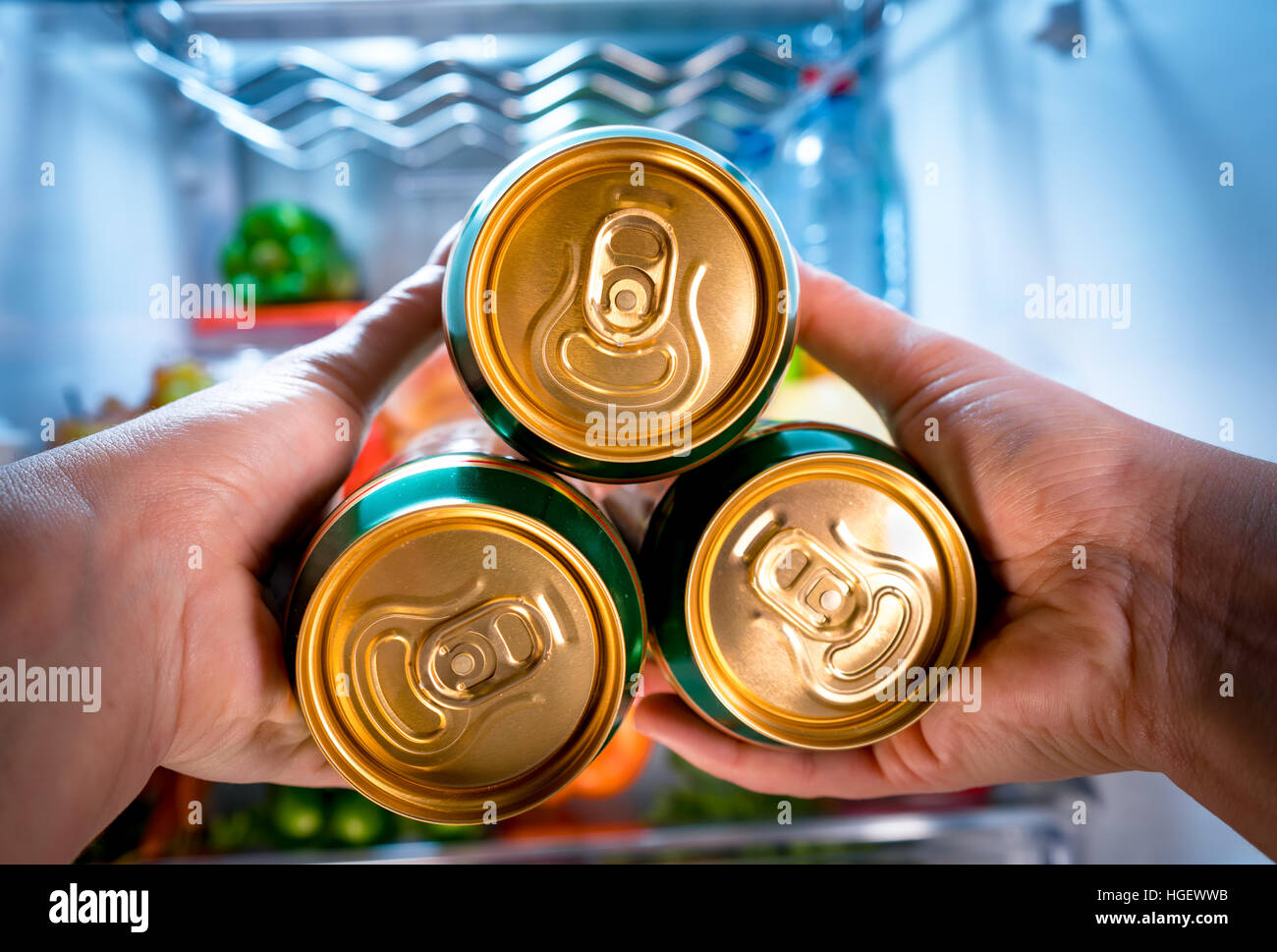 L'uomo prendendo la birra da un frigorifero Foto Stock