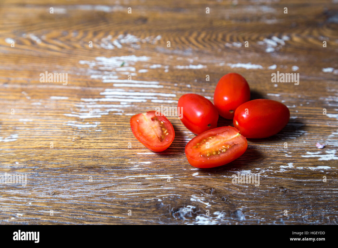 Gruppo di rossi freschi pomodori ciliegia su una tavola di legno Foto Stock