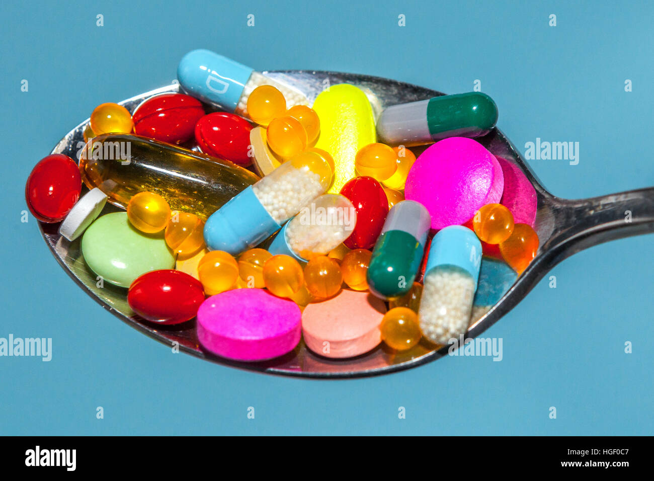 Molte compresse colorate su un cucchiaio Foto Stock