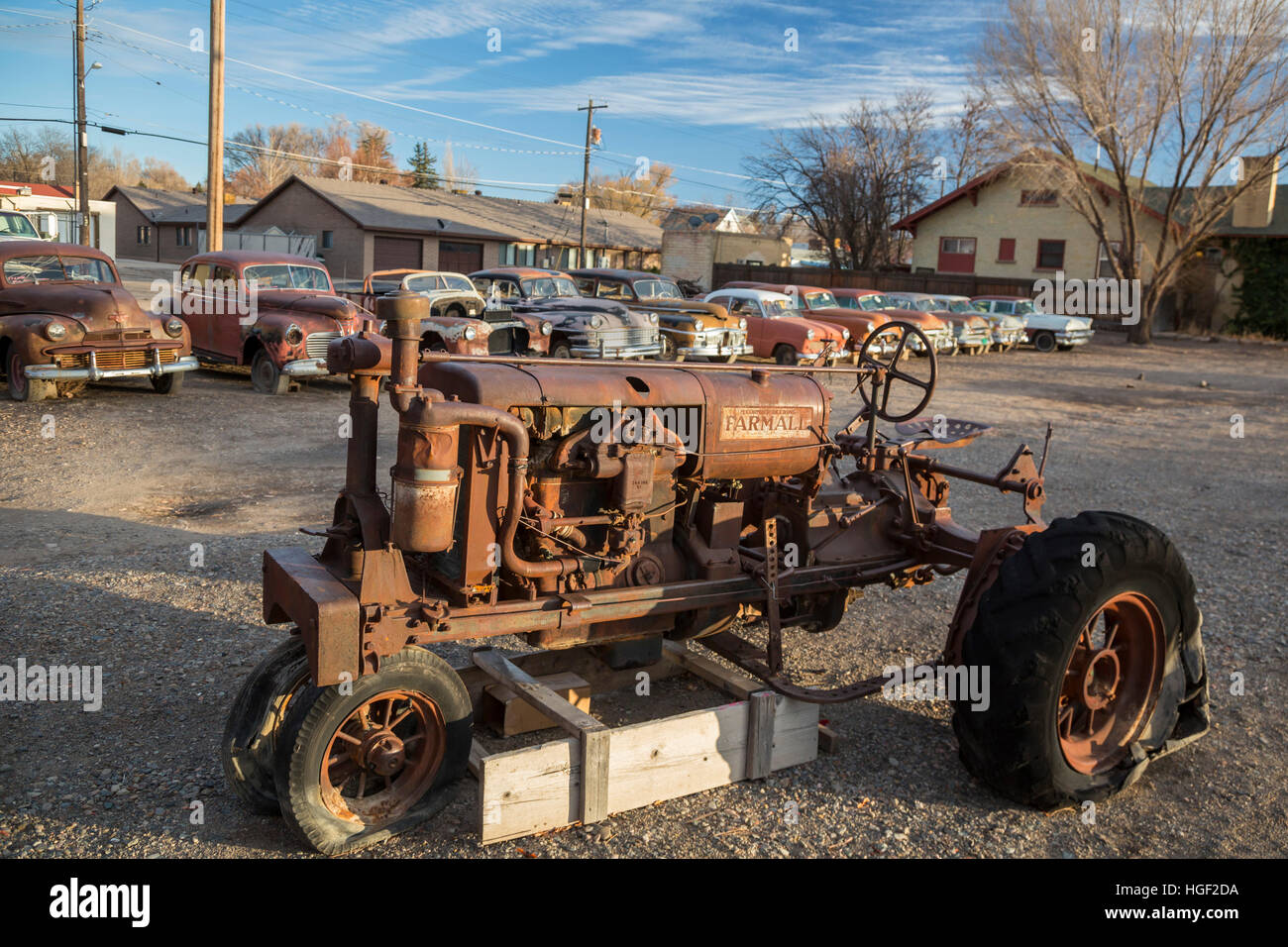 Delta, Colorado - arrugginito automobili classiche e un trattore Serie Farmall sul display alla Orval's automobili usate. Foto Stock