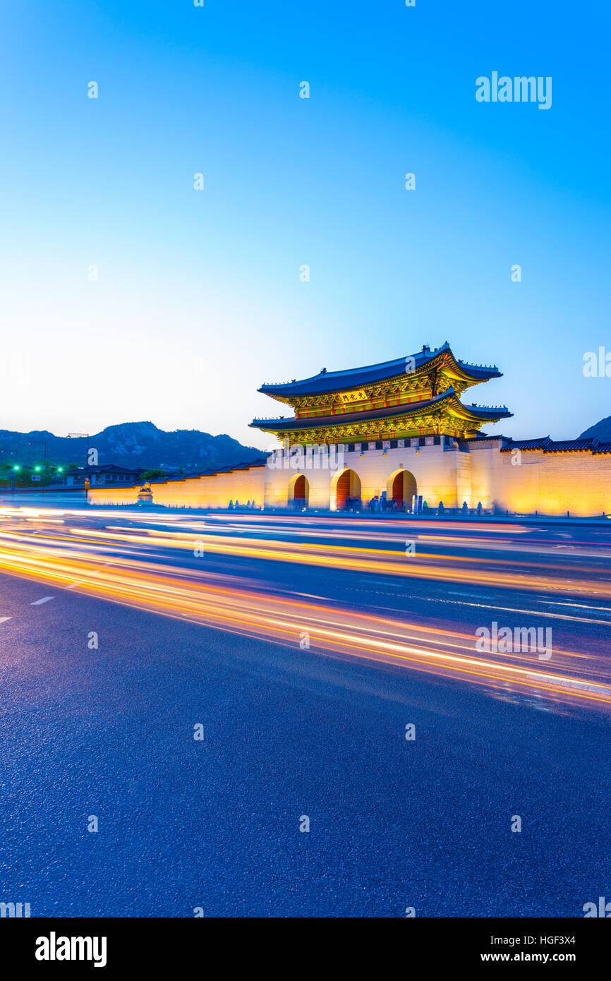 La presenza di striature colorate luci auto passando di fronte illuminata di gate Gwanghuamun, ingresso alla storica Gyeongbokgung Palace Foto Stock