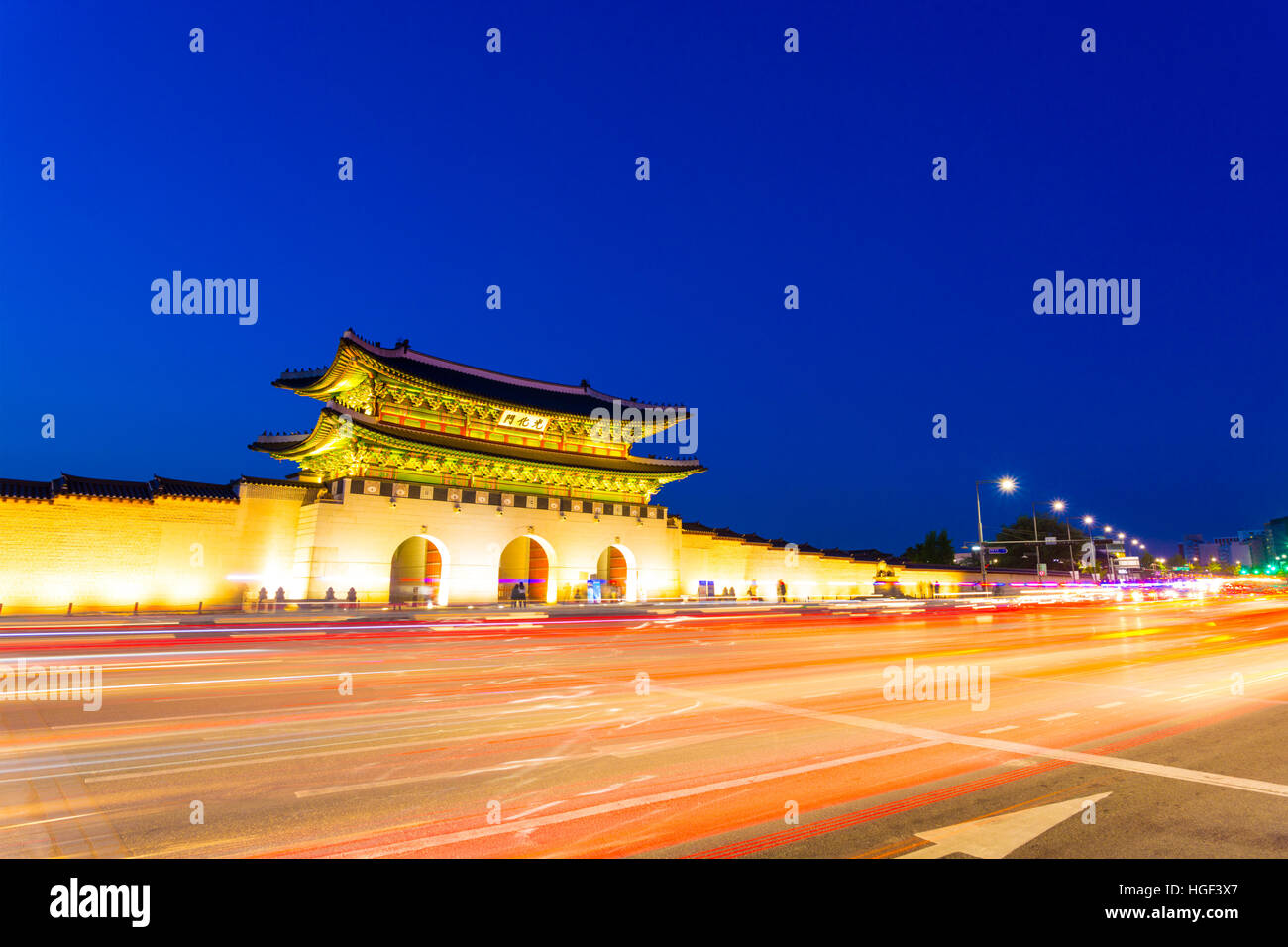 Esposizione a lungo la presenza di striature auto luci di coda lasciando la luce di coda anteriore di Gwanghwamun porta principale del palazzo Gyeongbokgung al crepuscolo Foto Stock