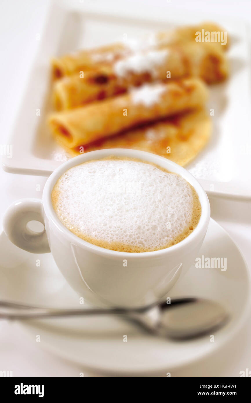 Tazza di cappuccino, crepes sfocata in background Foto Stock