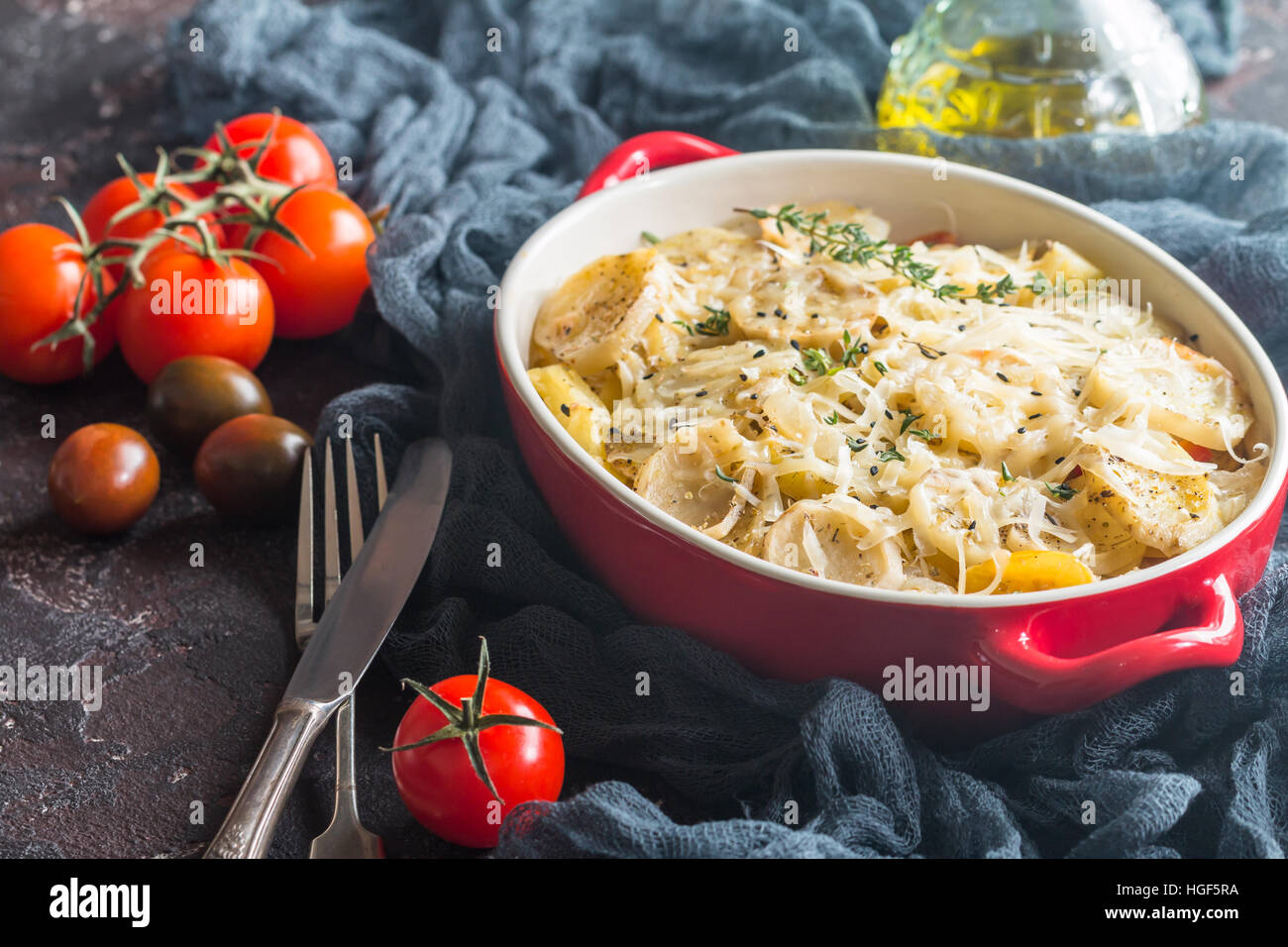 Patate gratinate, nel piatto rustico. Deliziose le patate a fette con cipolla, pomodoro, aglio, erbe e carne di pollo. Foto Stock