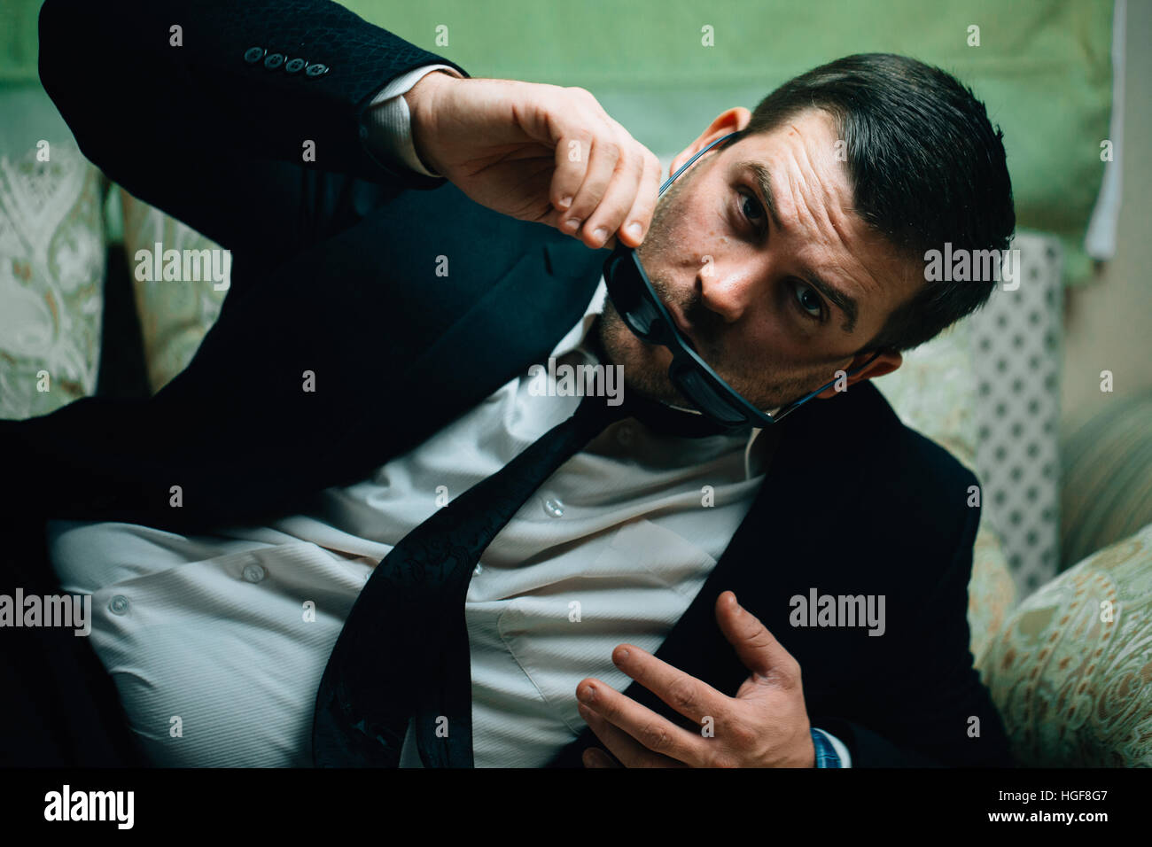 Imprenditore prende gli occhiali da sole e orologi sdraiato sul lettino Foto Stock