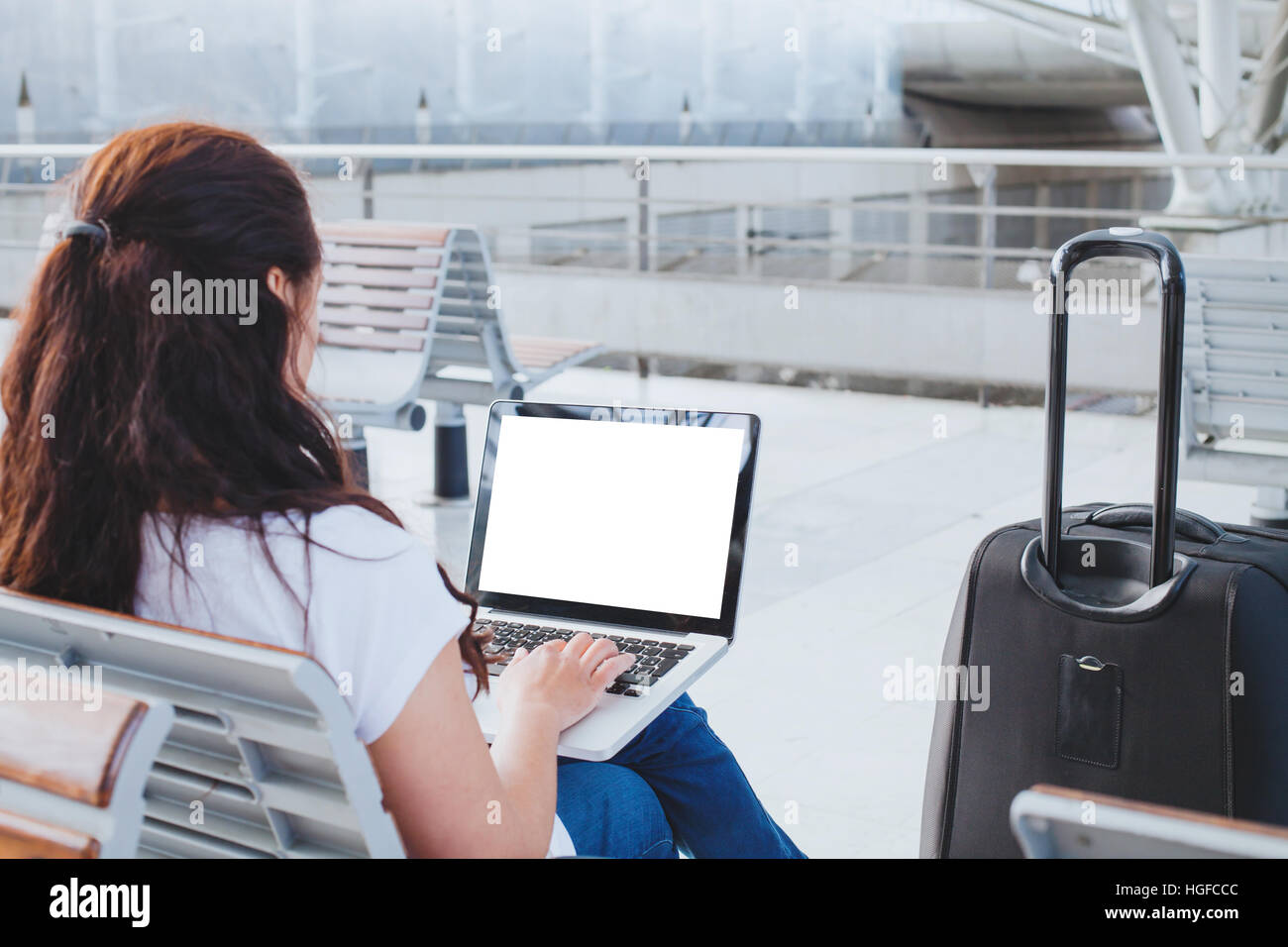Donna che utilizza il computer portatile in aeroporto e banking online o web check-in il passeggero guardando a svuotare lo schermo è vuoto Foto Stock