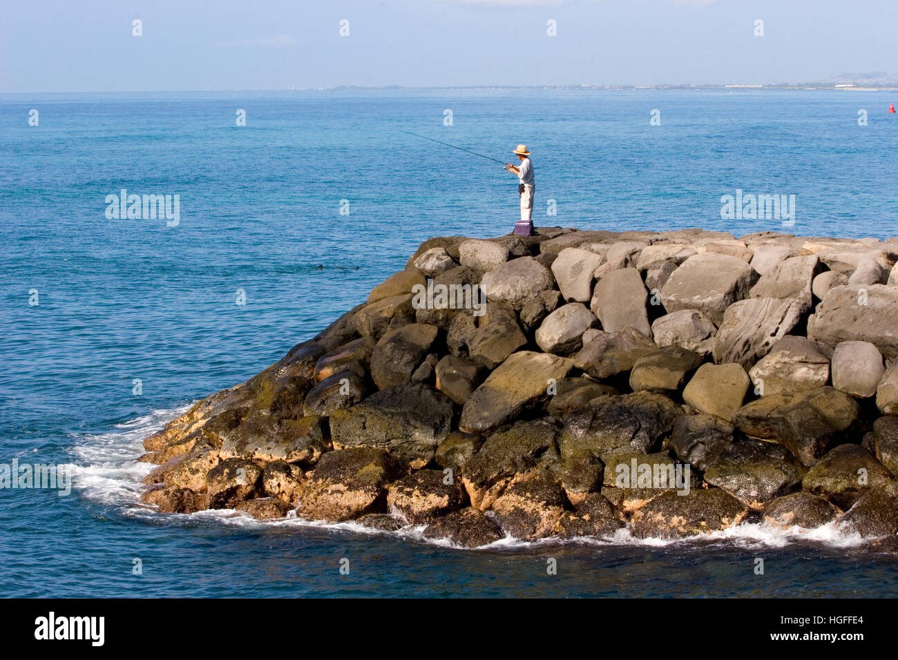 L'uomo la pesca da parete rocciosa su Oahu Hawaii Foto Stock