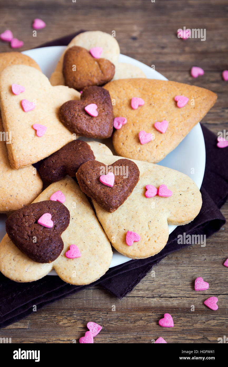 A forma di cuore i cookie su legno rustico sfondo per il giorno di San Valentino - festa in casa la pasticceria buiscuits biscotti, Valentino concetto di amore Foto Stock