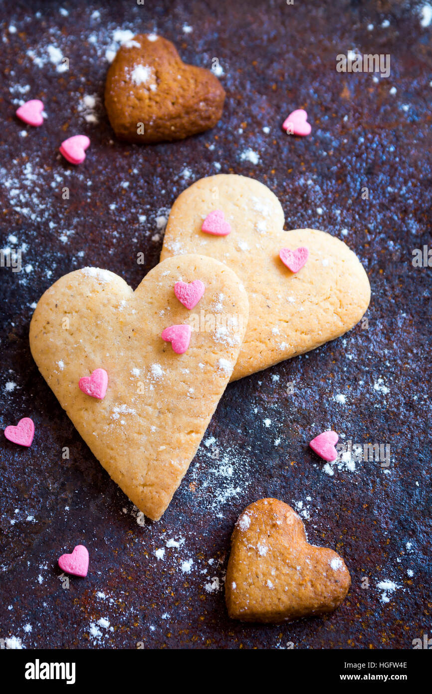 A forma di cuore i cookie da vicino per il giorno di San Valentino - festa in casa la pasticceria buiscuits cookie sul rustico vassoio metallico, Valentino amore concetto Foto Stock