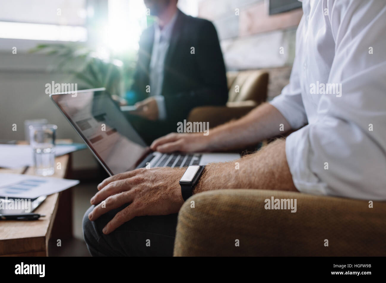 Imprenditore lavora su computer portatile durante la riunione aziendale. La gente di affari avente una riunione in ufficio. Foto Stock