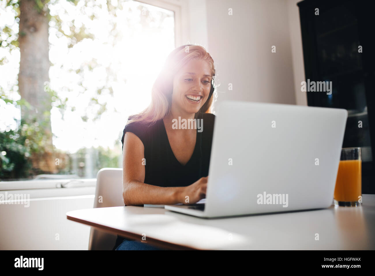 Piscina colpo di felice rilassante femmina in cucina e di lavoro sul computer portatile. La donna lo studio a casa con il computer portatile. Foto Stock