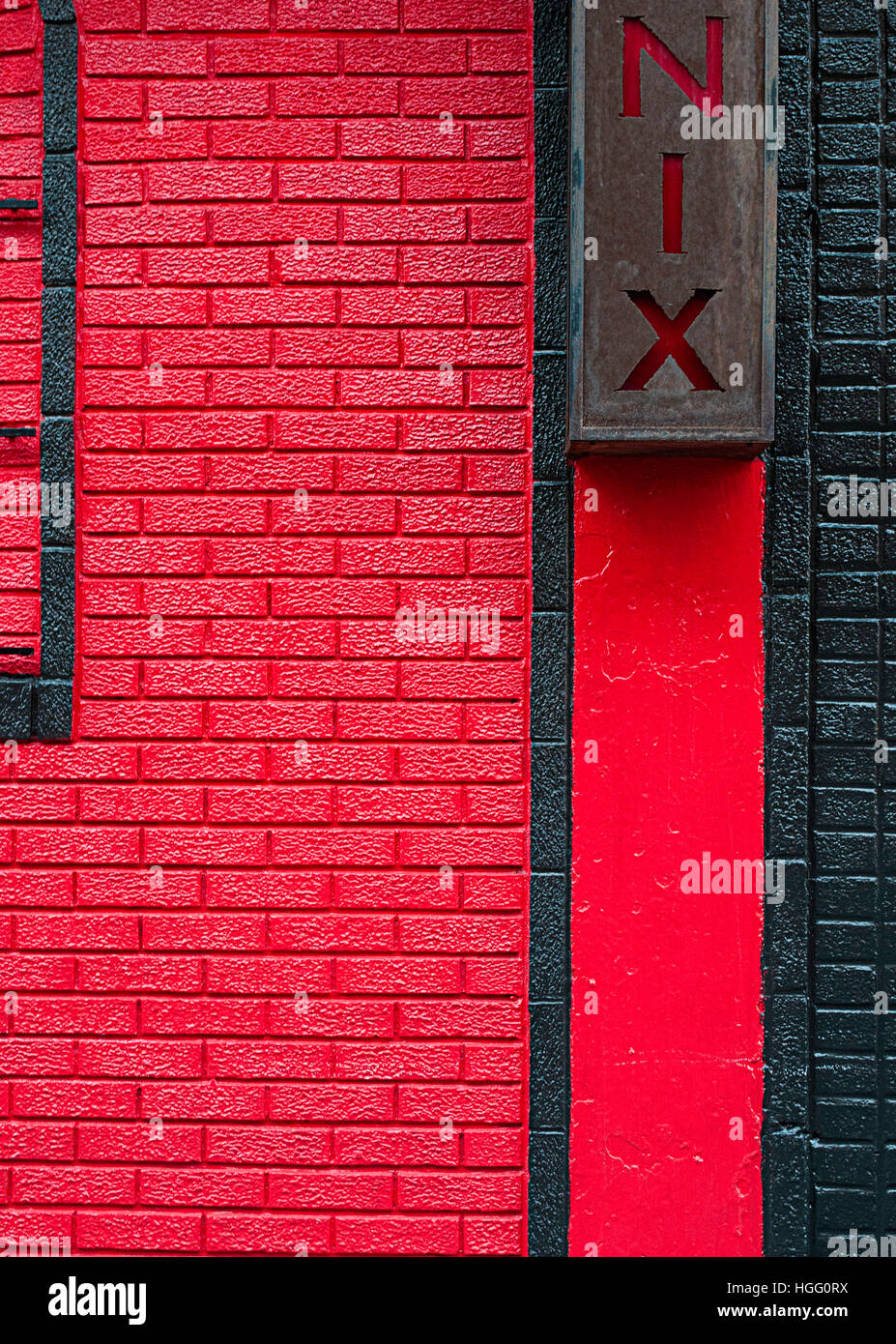 Un muro di mattoni dipinto di rosso al Phoenix bar The East Village a New York City. Foto Stock