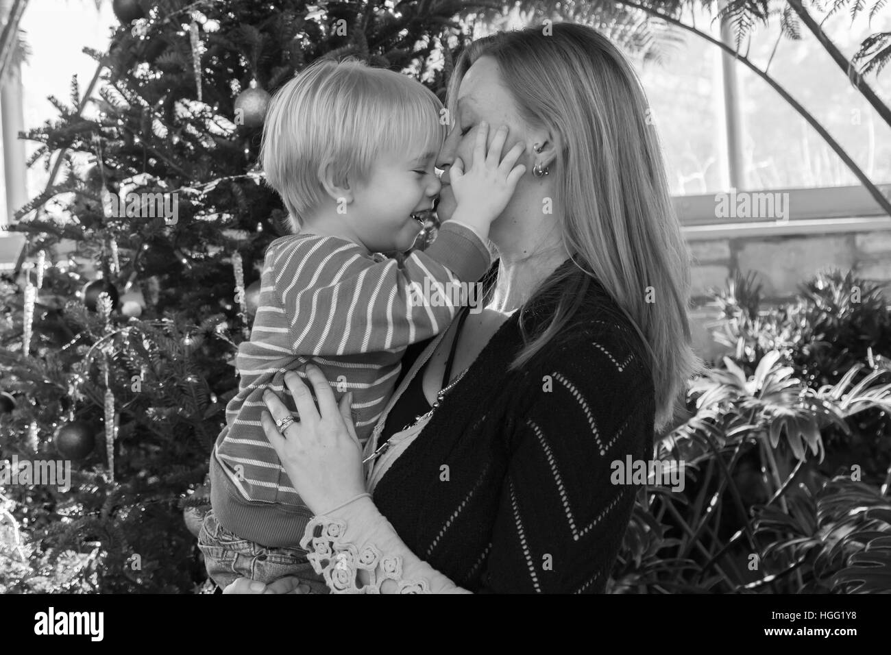 Madre e figlio di fronte a un albero di Natale. Foto Stock