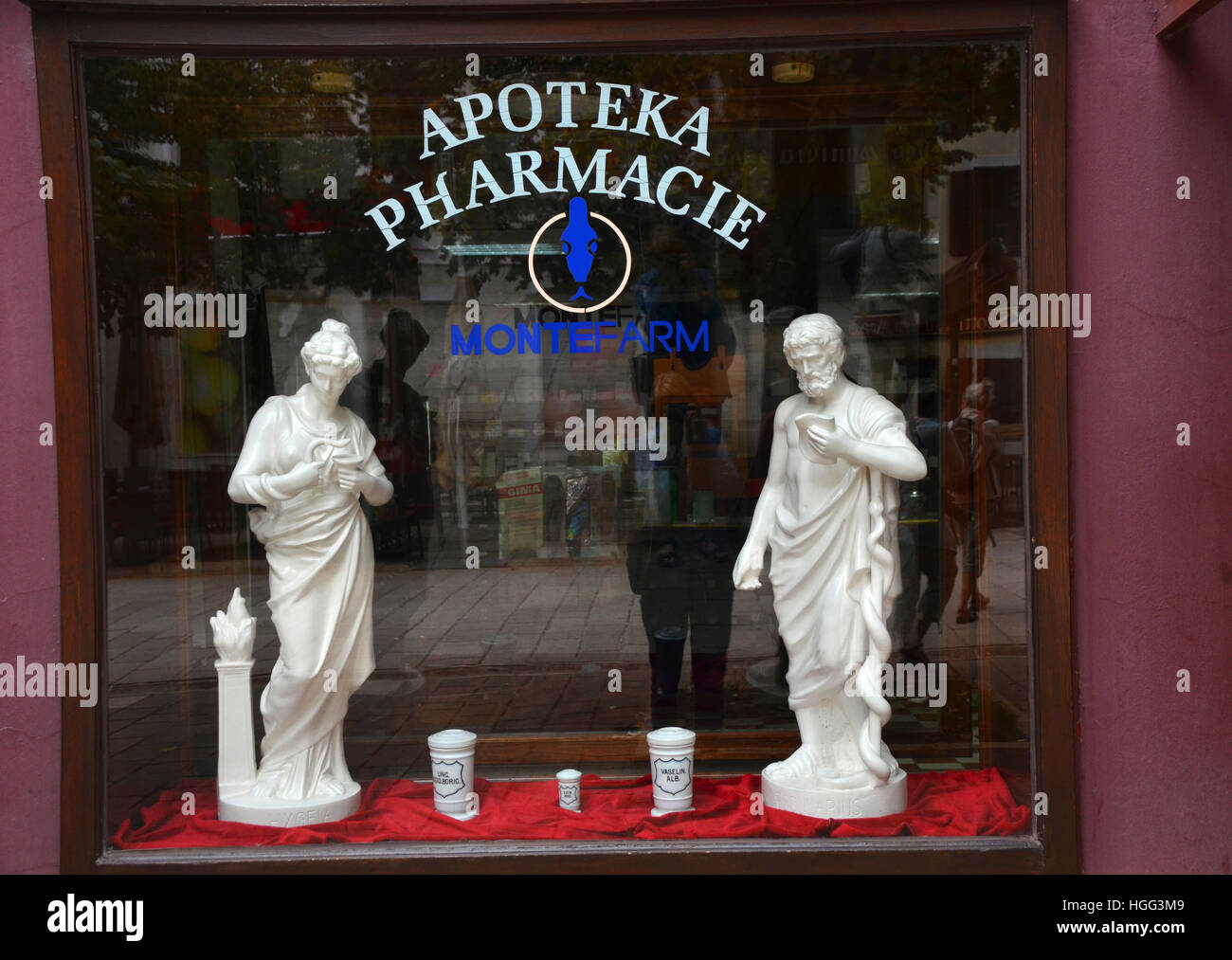 Farmacia shop finestra raffigurante le statue di divinità greche della guarigione e della medicina - Hygeia e suo padre Asklepius. Foto Stock
