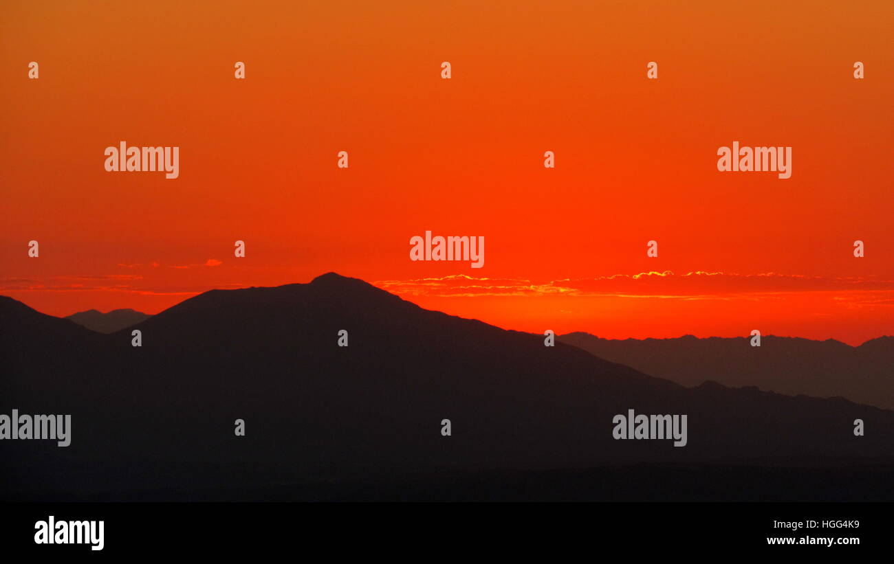 La montagna solitaria bagnata in rosso profondo pre-sunrise colori e cielo Foto Stock