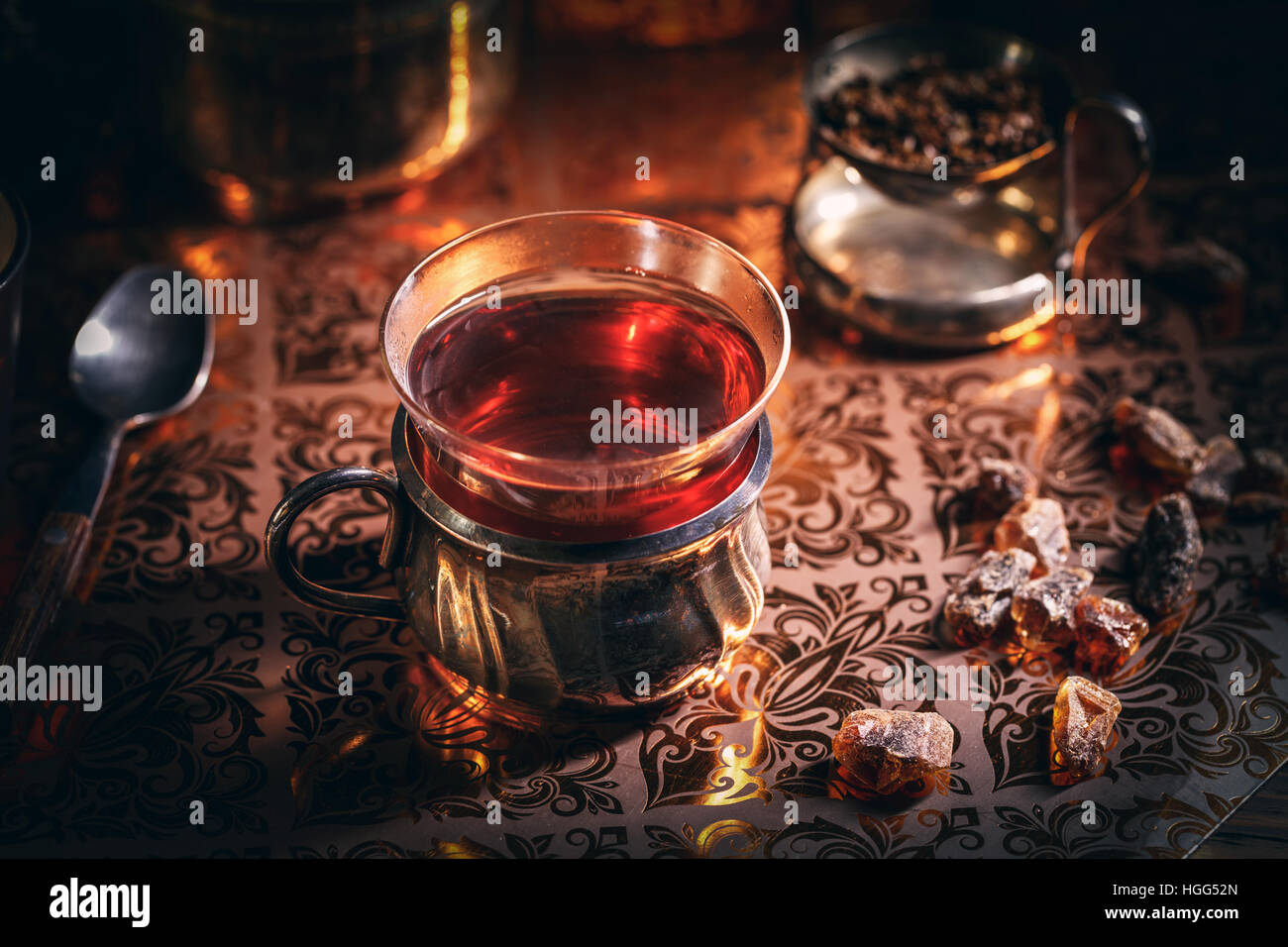 Il tè nero in un bicchiere di vetro a lume di candela Foto Stock