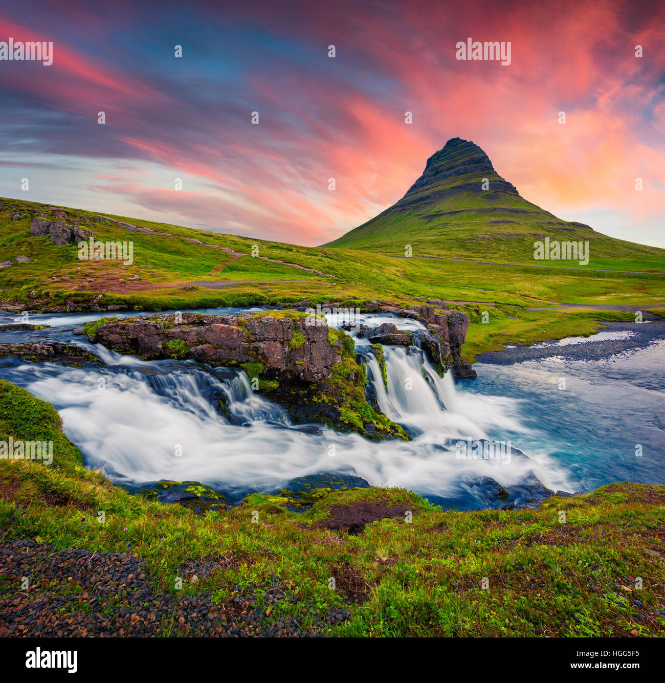 Estate tramonto sulla famosa cascata Kirkjufellsfoss Kirkjufell e montagna. Serata drammatica scena sulla penisola Snaefellsnes. Foto Stock