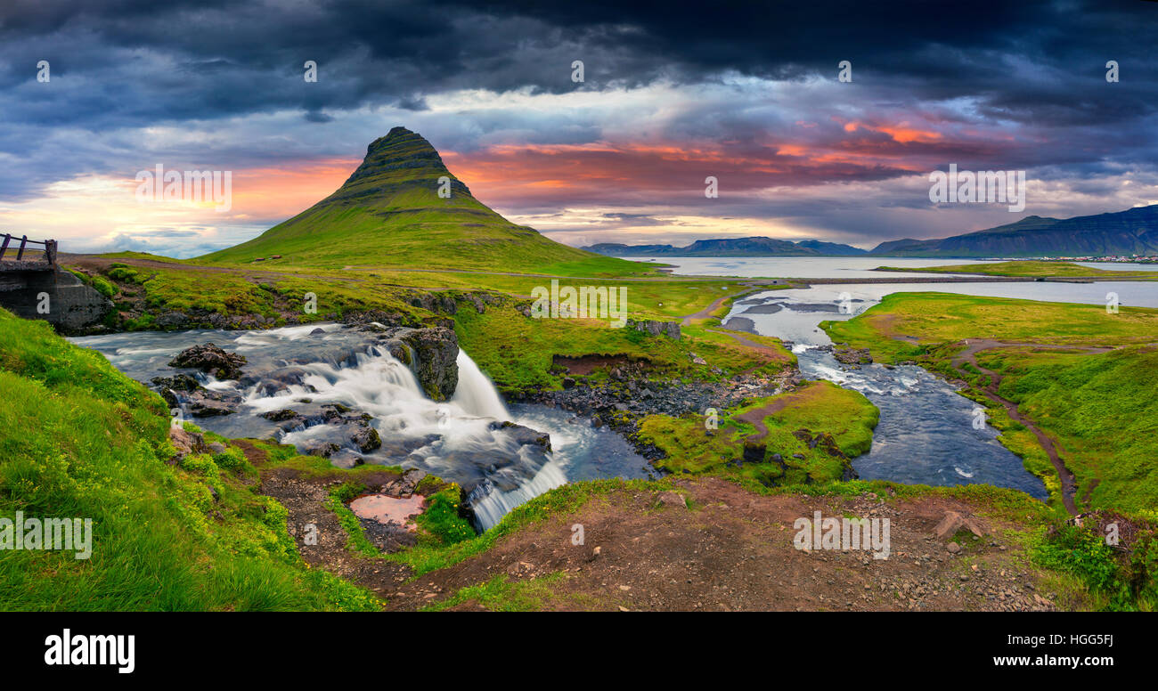 Estate tramonto sulla famosa cascata Kirkjufellsfoss Kirkjufell e montagna. Serata spettacolare panorama della penisola di Snaefellsnes. Foto Stock