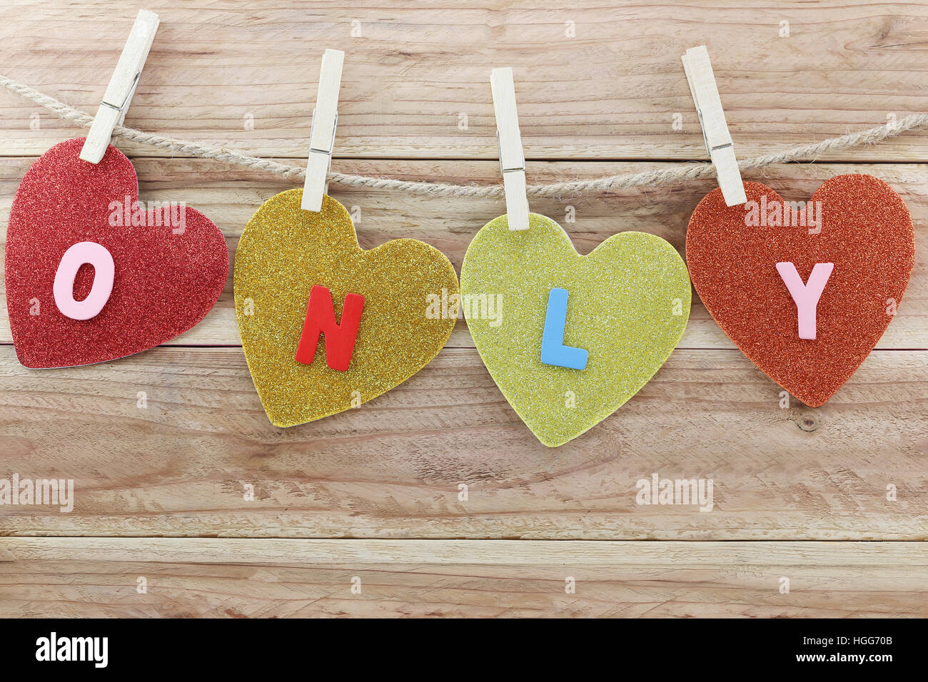 Carta forma di cuore appeso a una corda di canapa in legno marrone di sfondo e testo sono di solo,concetto di amore e il giorno di San Valentino. Foto Stock