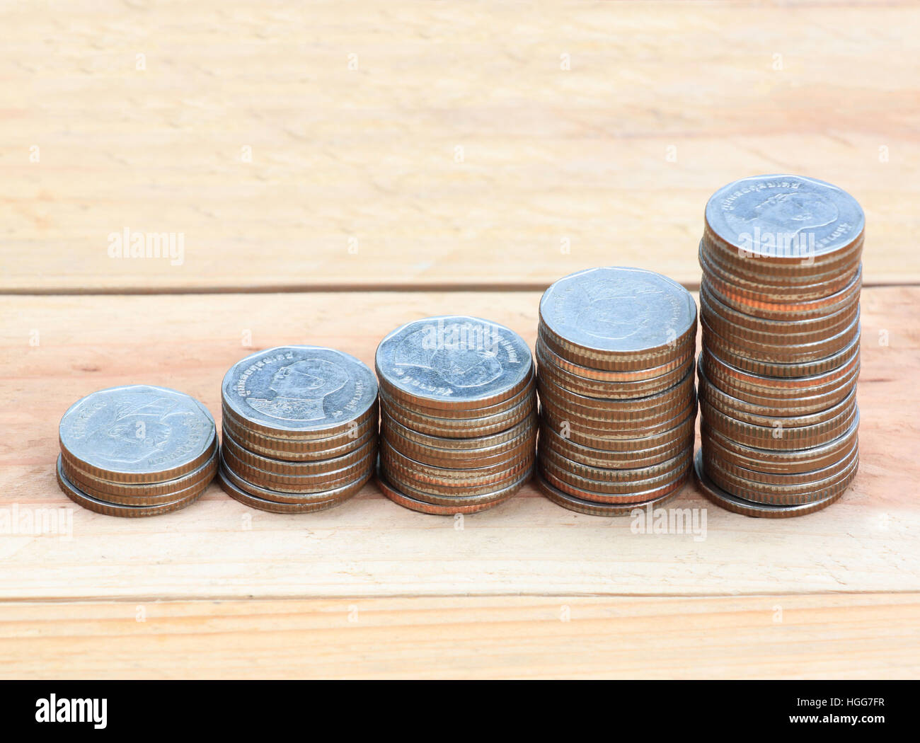 Moneta d'argento stack nella crescita aziendale concetto su pavimento di legno. Foto Stock