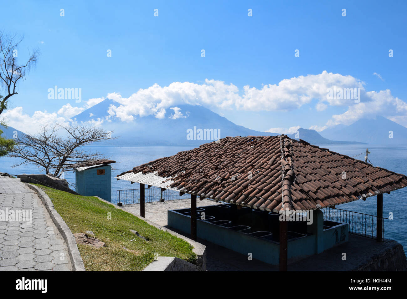 Stazione di lavaggio w/ tetto rotto dal lago con il vulcano sullo sfondo Foto Stock