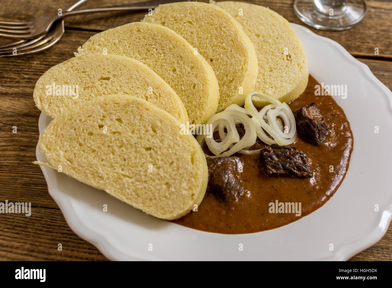 In casa gulasch di manzo con gnocchi di patate e cipolla sulla tavola di legno Foto Stock