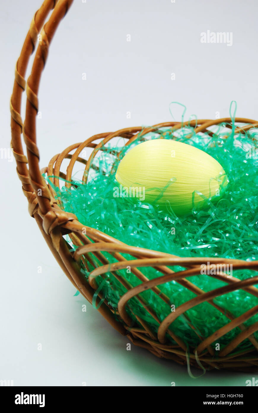 Giallo uovo in una vacanza di Pasqua con cestello fake erba. Foto Stock