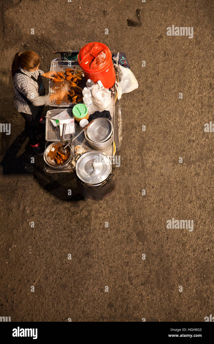 Donna con Food Cart sulla Strada di Sukhumvit Road di notte a Bangkok, in Thailandia Foto Stock