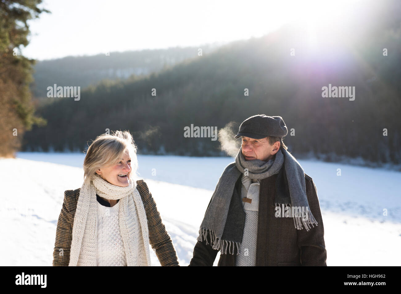 Bella coppia senior in una passeggiata sulla soleggiata giornata invernale Foto Stock